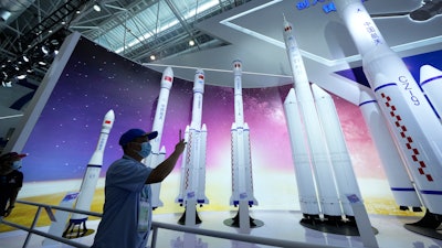 A visitor takes photos of replicas of space launch rockets at Airshow China 2021 in Zhuhai, Sept. 29, 2021.