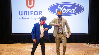 Unifor President Jerry Dias, left, elbow bumps Ryan Kantautas, Vice President of Human Resources at Ford Canada, at the start of formal contract talks in Toronto, Aug. 12, 2020.