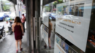 A sign about hiring domestic helpers in the Middle East outside an office in Manila, Philippines, Oct. 21, 2021.