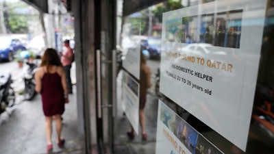 A sign about hiring domestic helpers in the Middle East outside an office in Manila, Philippines, Oct. 21, 2021.