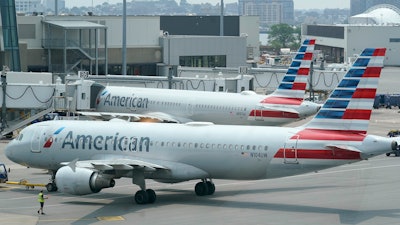 American Airlines jets prepare for departure near a terminal at Boston Logan International Airport, July 21, 2021.