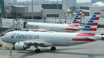 American Airlines jets prepare for departure near a terminal at Boston Logan International Airport, July 21, 2021.