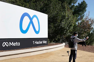A Facebook employee in front the company's new name and logo outside its headquarters in Menlo Park, Calif., Oct. 28, 2021.