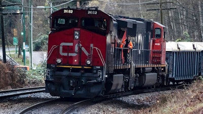 In this Nov. 27, 2020 file photo, a Canadian National rail worker stands on an idle locomotive as protesters opposed to the Trans Mountain pipeline expansion block rail lines in Burnaby, British Columbia. After walking away from its effort to buy Kansas City Southern railroad earlier this month, Canadian National continues to face investor pressure to make changes in its operation. The London-based investment firm TCI Fund — which owns about 5% of CN’s stock — is pressing for CN to overhaul its board, get a new CEO and improve its own operations.