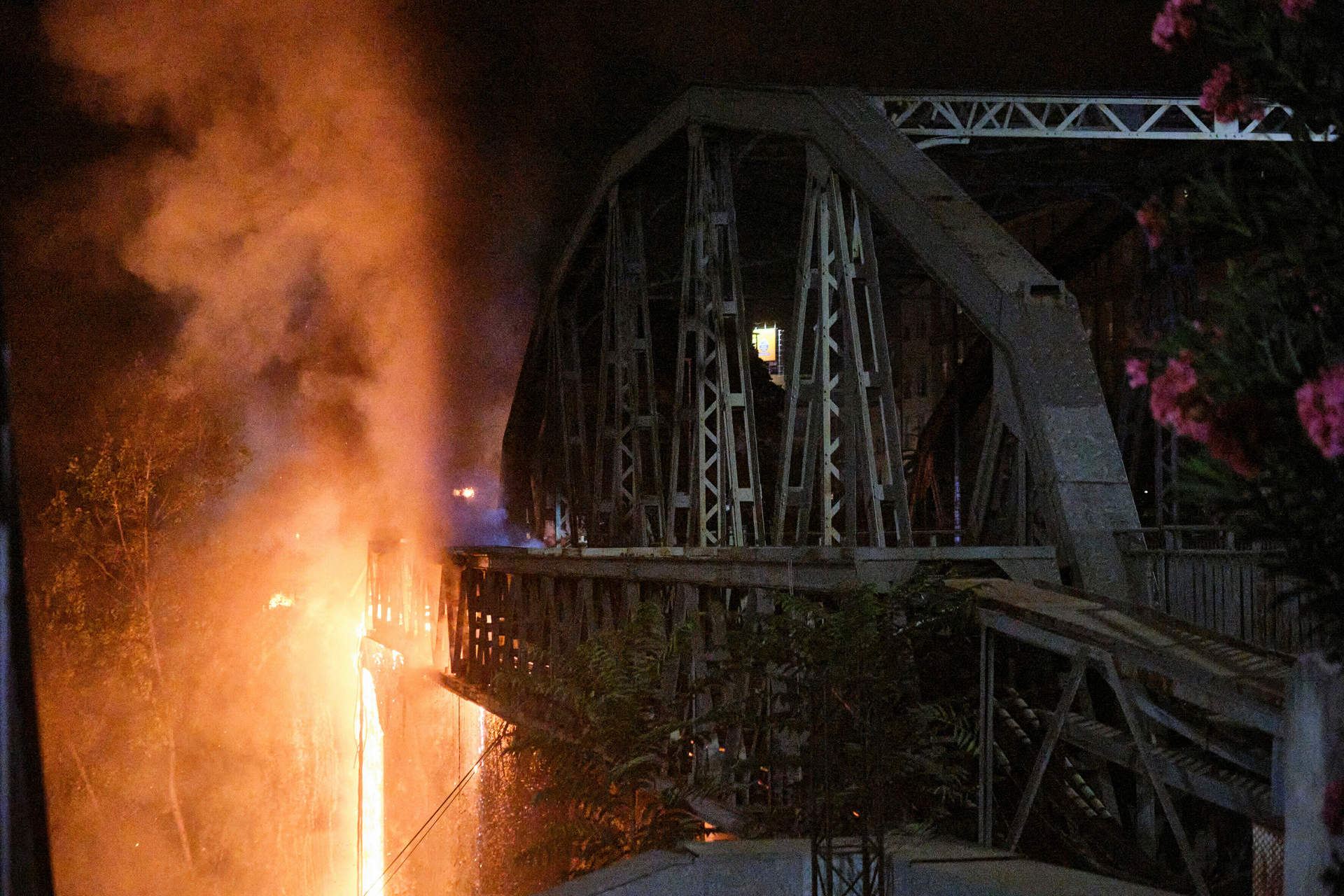 Flames engulf the Industry Bridge in Rome, early Sunday, Oct. 3, 2021. A blaze, possibly sparked by a gas canister explosion, destroyed part of an historic bridge spanning the Tiber River in Rome before firefighters extinguished the flames early Sunday.