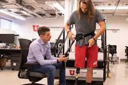 University of Utah mechanical engineering assistant professor Tommaso Lenzi, left, helps Alec McMorris put on an experimental exoskeleton that Lenzi has developed for lower-limb amputees.