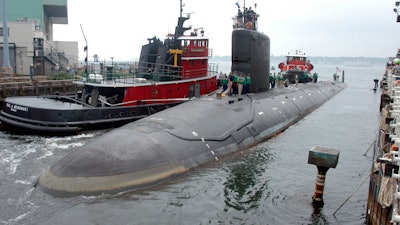 In this Friday, July 30, 2004 file photo, the U.S.S. Virginia returns to the Electric Boat Shipyard in Groton Conn., after its first sea trials. A Navy nuclear engineer with access to military secrets has been charged with trying to pass information about the design of American nuclear-powered submarines to someone he thought was a representative of a foreign government but who turned out to be an undercover FBI agent, the Justice Department said Sunday, Oct. 10, 2021.