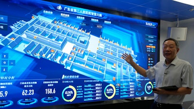 Tian Junzhang, president of Guangdong Second Provincial General Hospital, gestures in front of the monitoring screen of the hospital's cloud data center 'smart brain' in Guangzhou, China, Sept. 26, 2021.