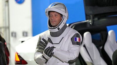 European Space Agency astronaut Thomas Pesquet of France adjusts his glove as he talks to family and friends before a launch attempt at the Kennedy Space Center, Cape Canaveral, Fla., April 23, 2021.