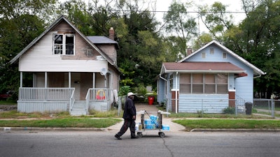 Sylvester Bownes walks with bottled and jugs full of water, Benton Harbor, Mich., Oct. 21, 2021.
