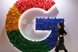 A woman walks past the logo for Google at the China International Import Expo in Shanghai, Nov. 5, 2018.