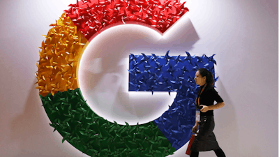 A woman walks past the logo for Google at the China International Import Expo in Shanghai, Nov. 5, 2018.