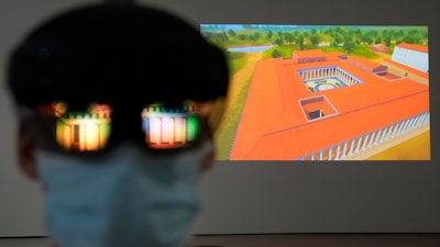 The image of an ancient temple reflected on a mixed-reality HoloLens headset worn by museum technician Kostas Baskakis at the Olympic Museum in Athens, Nov. 9, 2021.