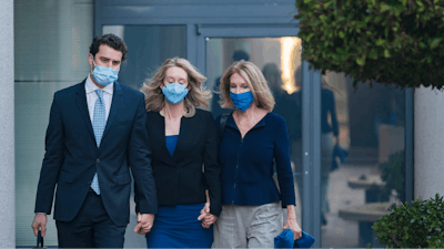 Elizabeth Holmes, center, walks into federal court in San Jose, Calif., Nov. 22, 2021.