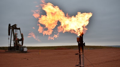 A flare burns natural gas at an oil well, Watford City, N.D., Aug. 26, 2021.