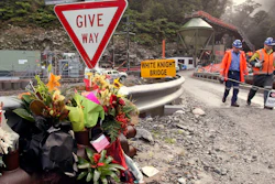 Workers walks past a bouquet of flowers for victims of mine explosion at the Pike River mine at Greymouth, New Zealand on June 28, 2011.