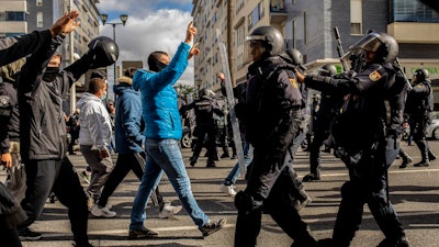 Protesters, left, march during a strike organized by metal workers in Cadiz, southern Spain, Tuesday, Nov. 23, 2021.