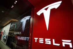This Feb. 9, 2019, file photo shows a sign bearing the company logo outside a Tesla store in Cherry Creek Mall in Denver. U.S. auto safety regulators are looking into a complaint from a Tesla driver that the company’s “Full Self-Driving” software caused a crash.
