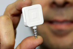 Dr. Greg Werner poses for a picture with his Square credit card reader at his office in New York, Jan. 5, 2015.