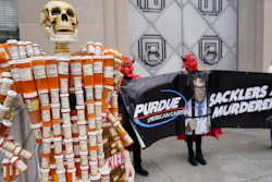 'Pill Mann,' made by Frank Huntley of Worcester, Mass., from his opioid prescription pill bottles, is displayed during a protest outside the Department of Justice, Washington, D.C., Dec. 3, 2021.