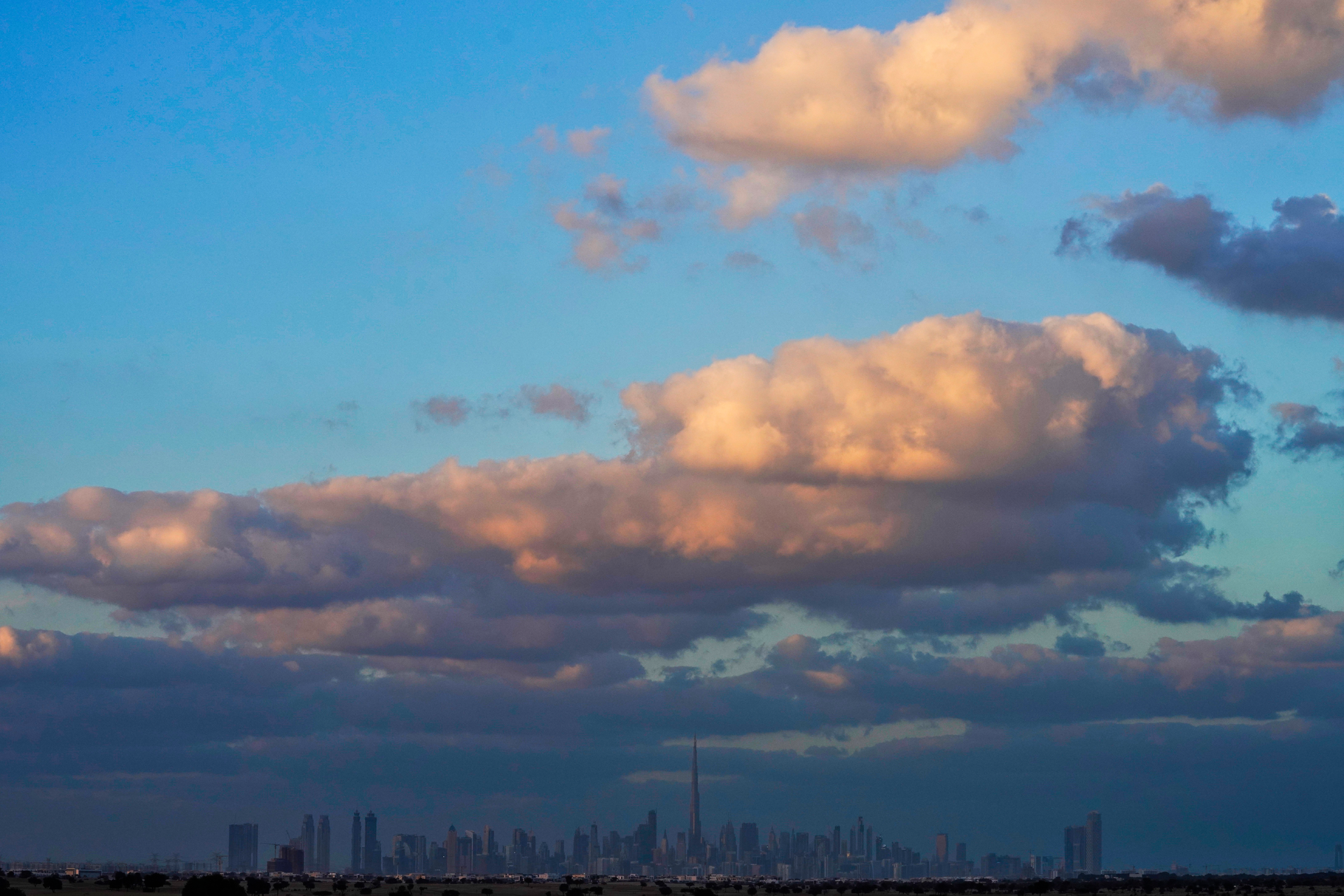 The skyline of downtown Dubai on a rare cloudy day is seen at sunset in Dubai, United Arab Emirates, Saturday, Dec. 4, 2021.