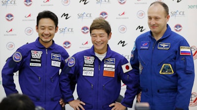 Roscosmos cosmonaut Alexander Misurkin, right, space flight participants Yusaku Maezawa, center, and Yozo Hirano attend a news conference at the Gagarin Cosmonauts' Training Center outside Moscow, Oct. 14, 2021.