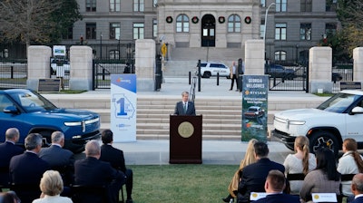 Georgia Gov. Brian Kemp, flanked by Rivian electric trucks, at a press conference in Atlanta, Dec. 16, 2021.