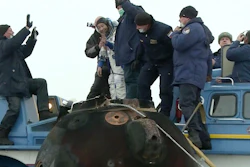 A Russian space agency rescue team helps Yusaku Maezawa depart the capsule shortly after landing, Dec. 20, 2021.
