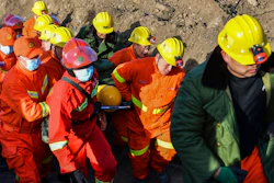 In this photo released by China's Xinhua News Agency, rescuers evacuate a trapped miner from a flooded coal mine in Xiaoyi city in northwestern China's Shanxi Province, Friday, Dec. 17, 2021. Crews have safely rescued 20 of 21 Chinese coal miners trapped inside a flooded shaft, with one still missing.