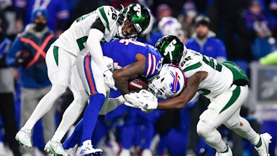 New York Jets Brandin Echols, left, and Quincy Williams, right, tackle the Buffalo Bills' Stefon Diggs during the first half of a game in Orchard Park, N.Y., Jan. 9, 2022.