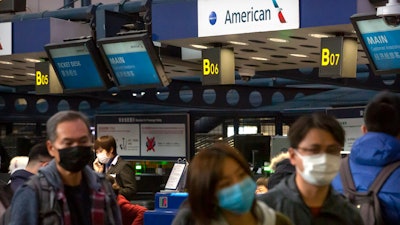 Travelers line up to check in for an American Airlines flight to Los Angeles at Beijing Capital International Airport, Jan. 30, 2020.