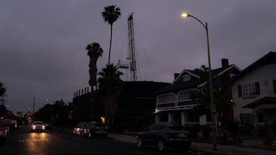 A vehicle drives past the Jefferson oil drill site in Los Angeles, June 2, 2021.