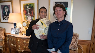 Marina Picasso, right, and Florian Picasso pose with a ceramic work of Pablo Picasso, Cologny, Switzerland, Jan. 25, 2022.