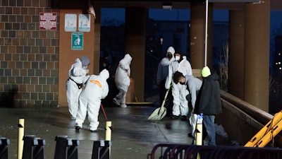 Staffs cleans the floor at the scene of a fatal fire at an apartment building in the Bronx on Sunday, Jan. 9, 2022, in New York.