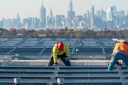 Electricians with IBEW Local 3 install solar panels on top of the Terminal B garage at LaGuardia Airport, New York, Nov. 9, 2021.