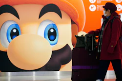 A traveler walks past an ad featuring a Nintendo character at Narita airport near Tokyo, Jan. 23, 2020.
