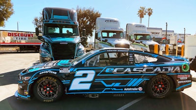 The No. 2 Ford sits in front of the Team Penske fully electric Freightliner eCascadia hauler, Penske Truck and Leasing, Ontario, Calif., Feb. 3, 2022.