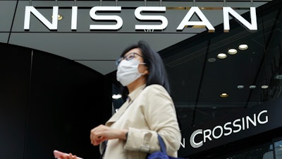 A woman walks by a Nissan showroom in Tokyo, May 11, 2021.