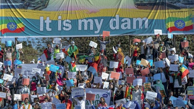 Ethiopians protest against international pressure on the government over the conflict in Tigray, below a banner referring to the Grand Ethiopian Renaissance Dam, Addis Ababa, May 30, 2021.