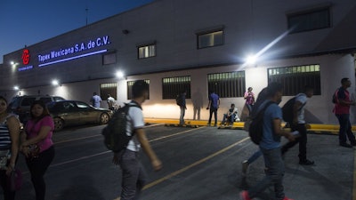 Workers gather outside a 'maquiladora' for car accessories in Matamoros, Mexico, March 21, 2017.