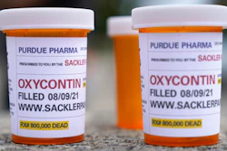 Fake pill bottles with messages about OxyContin maker Purdue Pharma are displayed during a protest outside the courthouse where the bankruptcy of the company is taking place in White Plains, N.Y., on Aug. 9, 2021. A judge said he is extending legal protections for members of the Sackler family, Wednesday, March 2, 2022, who own OxyContin maker Purdue Pharma by another three weeks to buy time to work out a new settlement to thousands of lawsuits over the opioid crisis.
