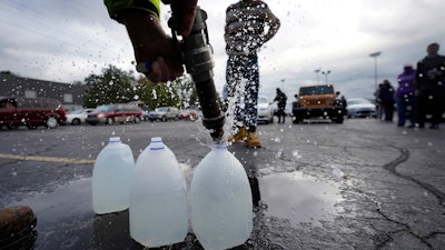 Kevin Stack of the Berrien County Road Department fills jugs with non-potable water in the Benton Harbor High School parking lot, Benton Harbor, Mich., Oct. 21, 2021.