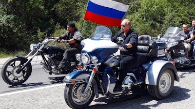 Russia's Prime Minister Vladimir Putin, foreground, rides a Harley-Davidson Lehman Trike as he arrives for the meeting with Russian and Ukrainian bikers at their camp near Sevastopol, in Ukraine's Crimea Peninsula, on July 24, 2010. Harley-Davidson halted motorcycle shipments to Russia and said its thoughts “continue for the safety of the people of Ukraine.”