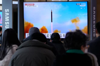 People watch a TV showing a file image of North Korea's missile launch during a news program at the Seoul Railway Station in Seoul, March 5, 2022.