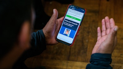 Ecuadorian immigrant Neptali Chiluisa shows the app that he uses for reporting his location to Immigration authorities, New York, Oct. 21, 2021.