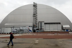 A man walks past a shelter covering the exploded reactor at the Chernobyl nuclear plant, Chernobyl, Ukraine, April 15, 2021.