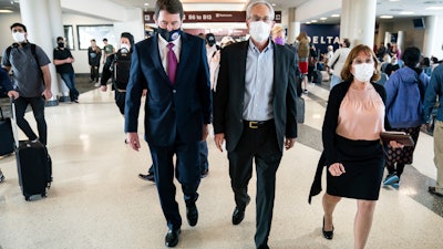Sen. Bill Hagerty, R-Tenn., left, walks with Greg Kelly, center, and his wife, Dee Kelly, Nashville International Airport, March 14, 2022.