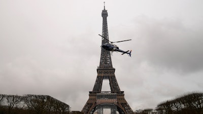A helicopter installs a new telecom transmission TDF antenna on the top of the Eiffel Tower in Paris, March 15, 2022.