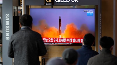 People watch a TV screen showing a news program reporting about North Korea's missile with file footage, Seoul, March 16, 2022.