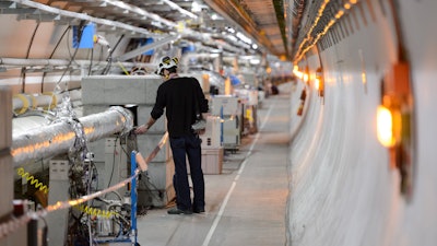 A technician works in the Large Hadron Collider tunnel of the European Organization for Nuclear Research (CERN), Meyrin, Switzerland, Feb. 16, 2016.